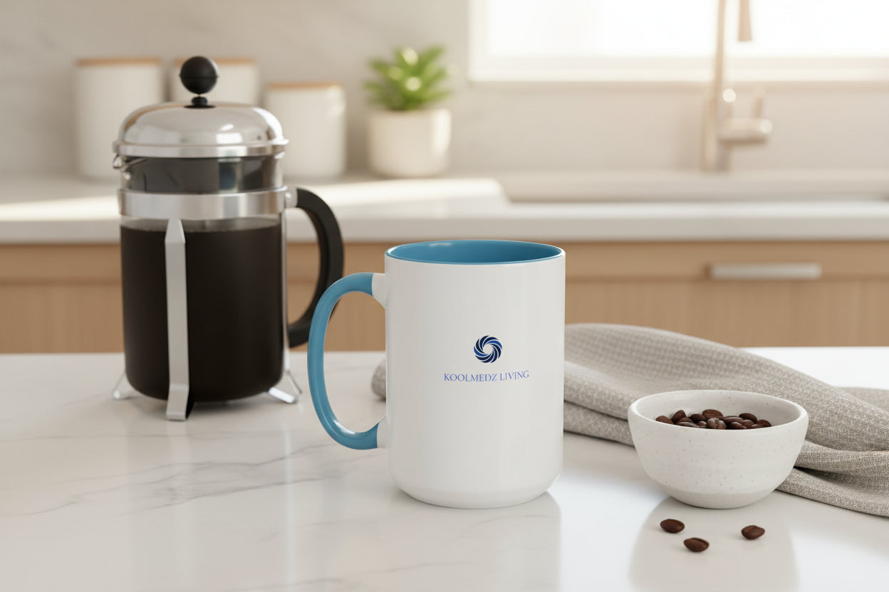 Ceramic mug with blue handle, white body, KoolMedz Living logo on front.
