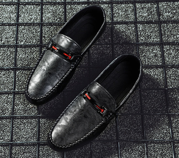 Black moc-toe slip-on loafers with red/gray strap detail, top view