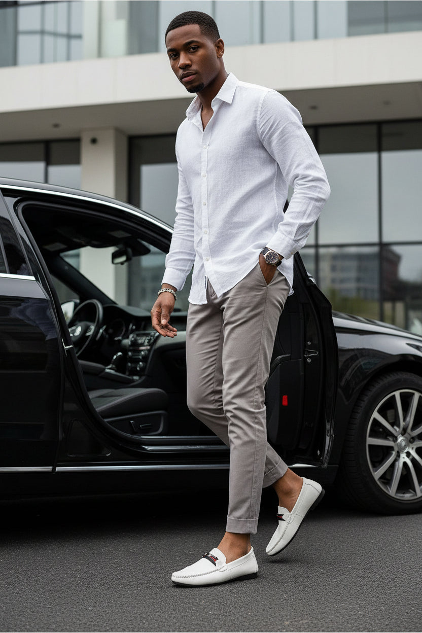 White slip-on loafers with red/gray strap detail worn with light trousers