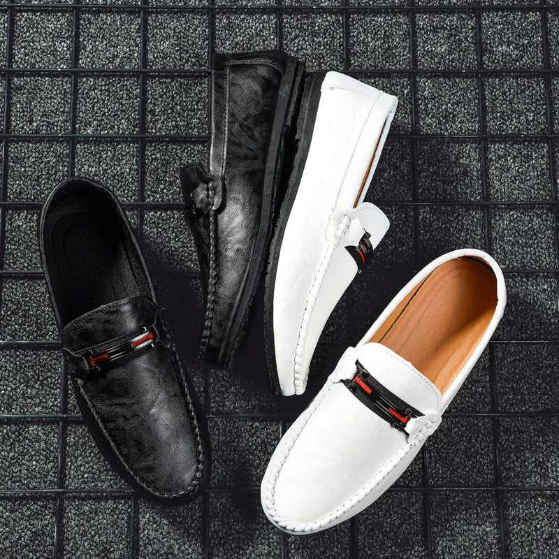 Pair of moc-toe slip-on loafers: black and white, with red/gray strap detail