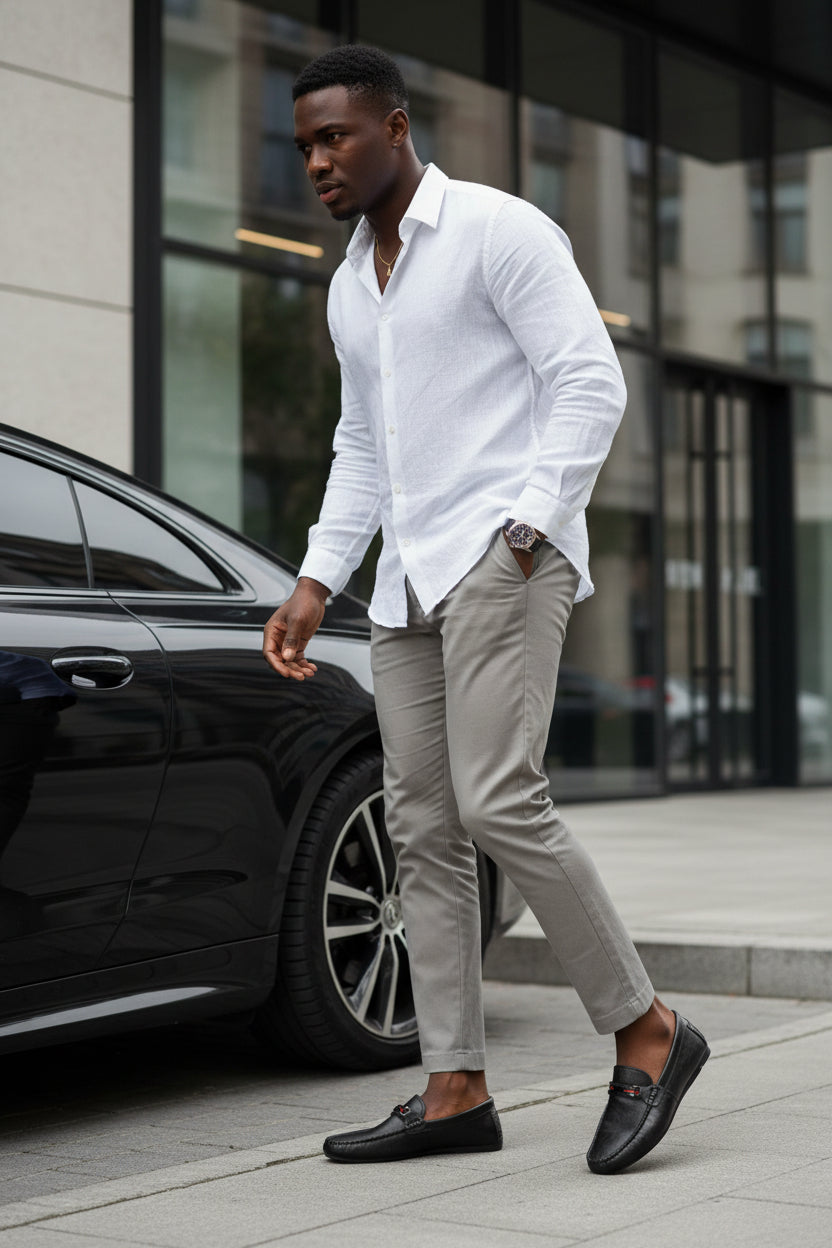 Man wearing black moc-toe slip-on loafers with red/gray strap detail