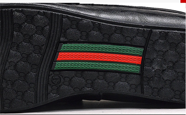 Underside of black loafer sole with green and red stripe accents