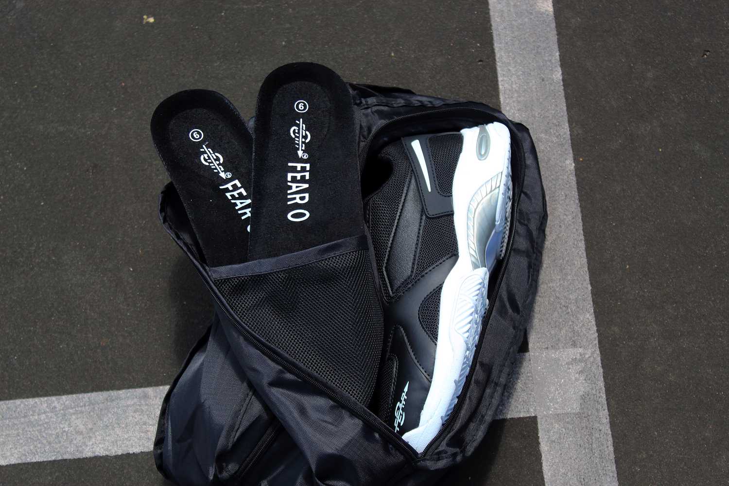 Black men's walking sneakers partially shown with shoe bag and inner lining