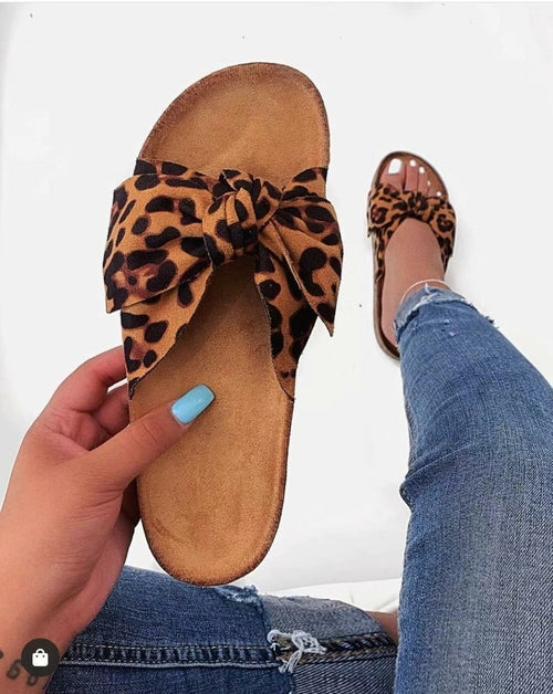 Leopard print bow slide sandals with bow detail on tan footbed