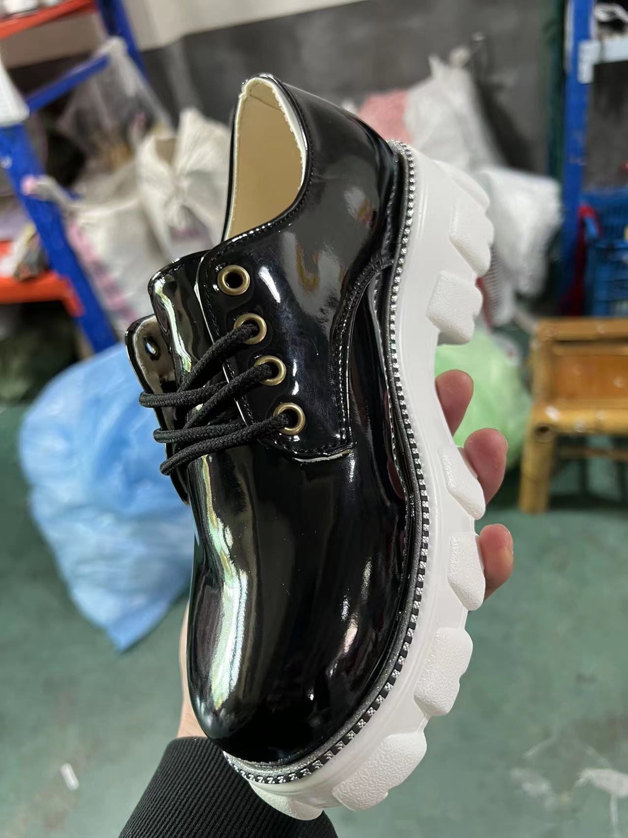 Black glossy platform lace-up shoe with side zipper and thick white lug sole