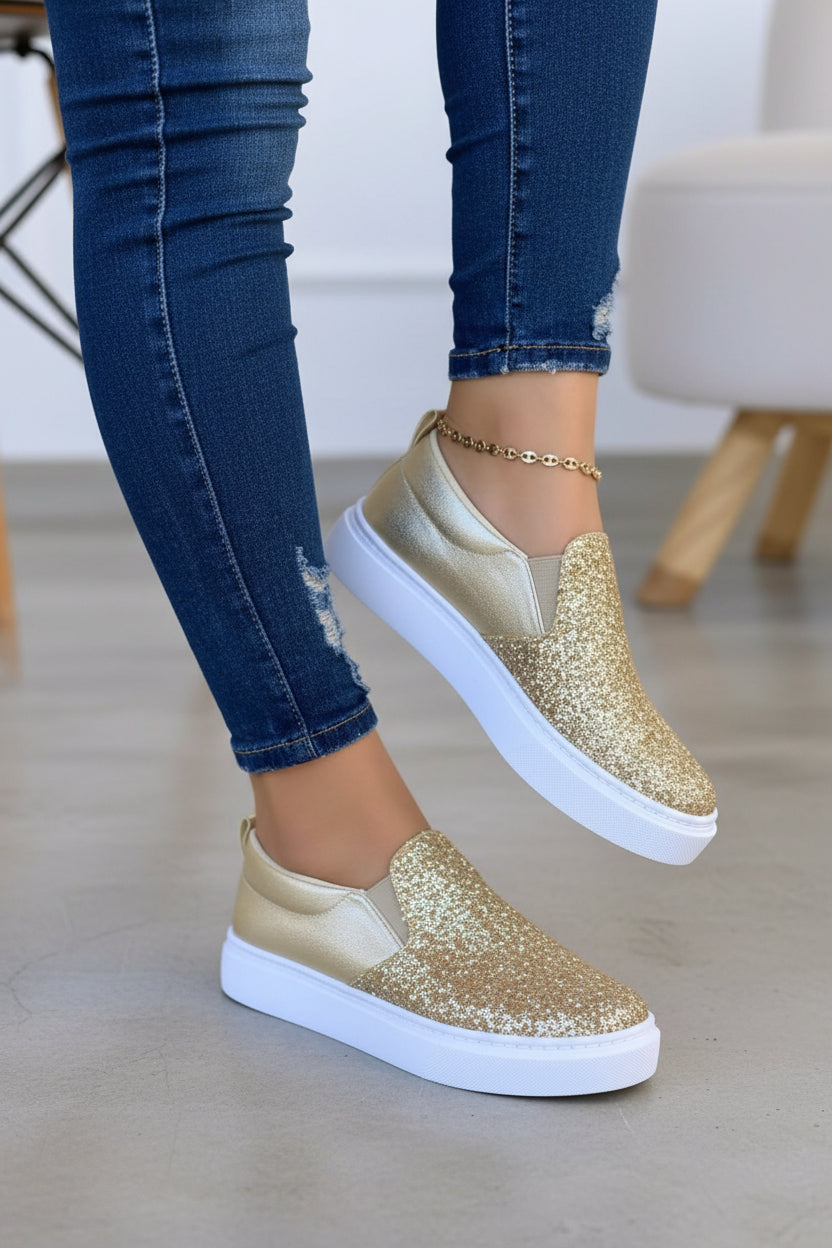 Women’s gold glitter slip-on platform sneakers with white sole and rounded toe.