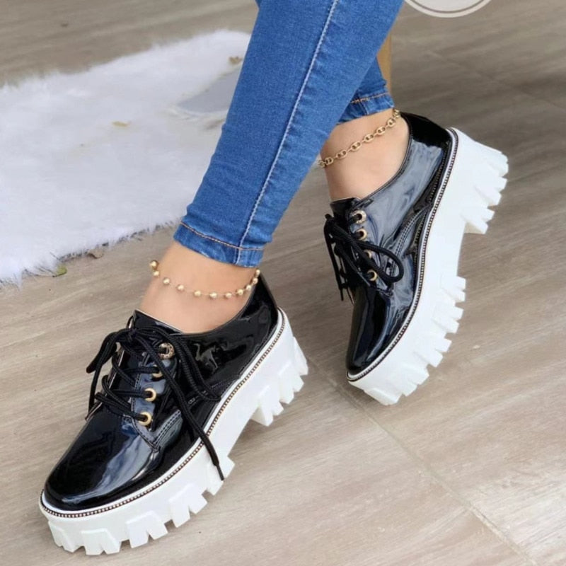 Black glossy platform lug-sole lace-up shoes with thick white tread and eyelets