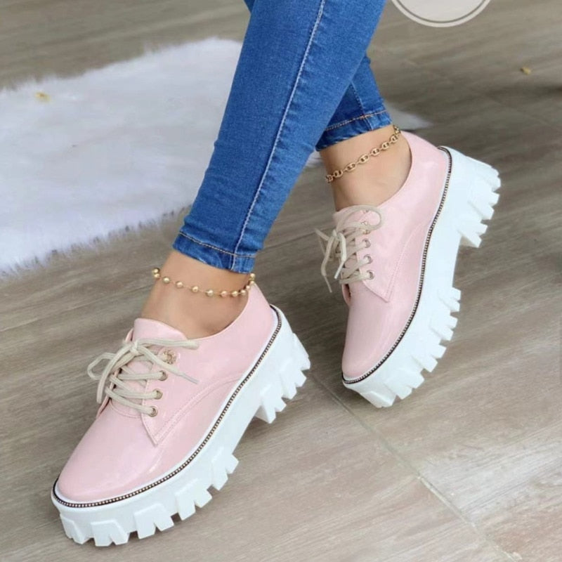 Light pink glossy platform lug-sole lace-up shoes with thick white tread and laces