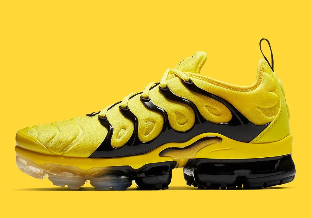 Yellow unisex sculpted-sole sneakers with black accents and air-cushion sole pods.