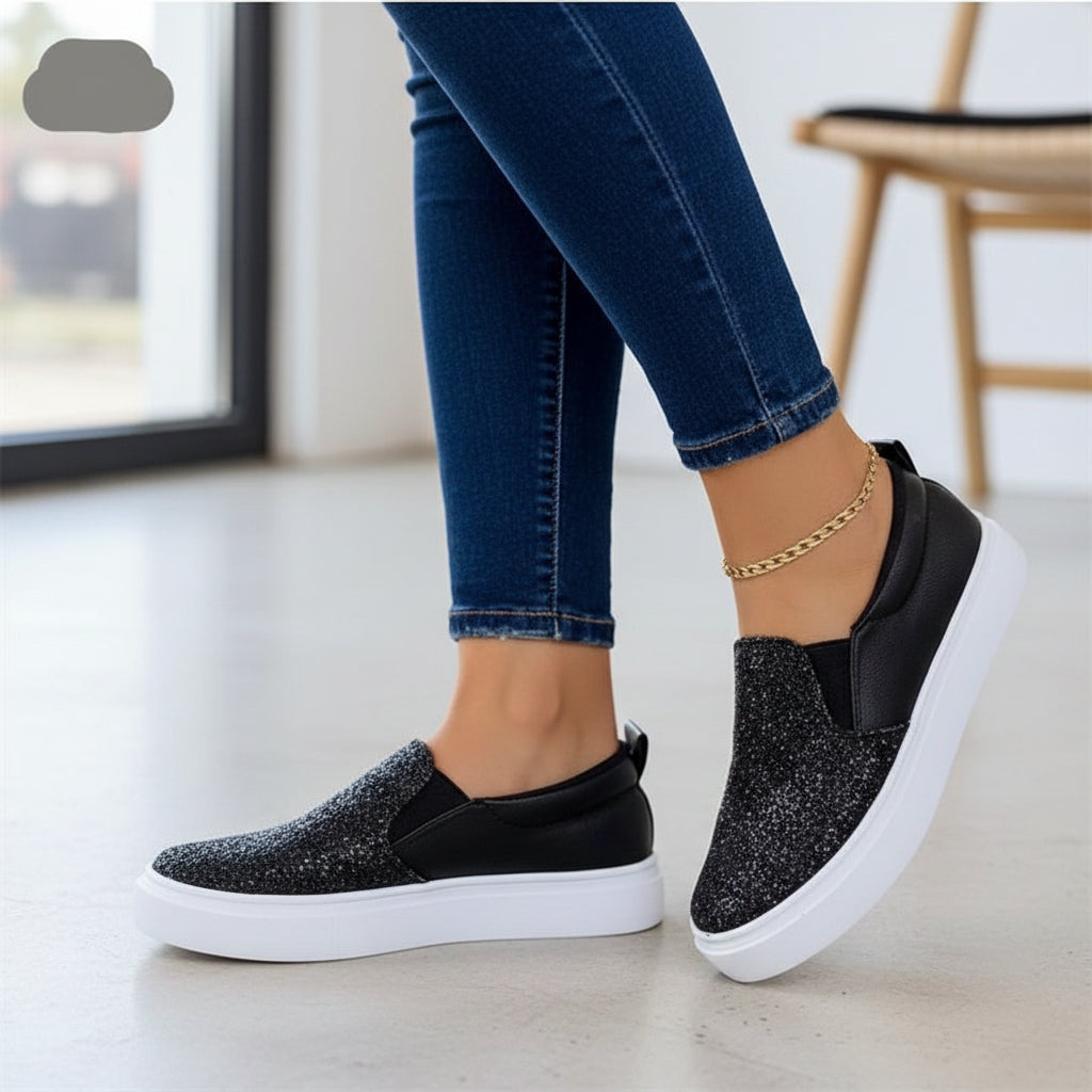 Women’s black glitter slip-on platform sneakers with white sole and cushioned top.