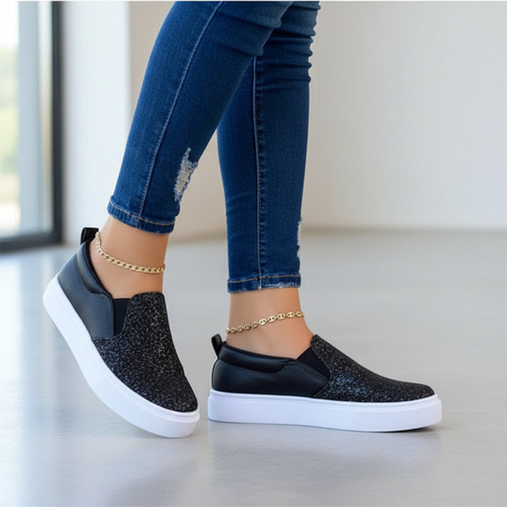 Women’s black glitter slip-on platform sneakers with white rubber sole, ankle fit.