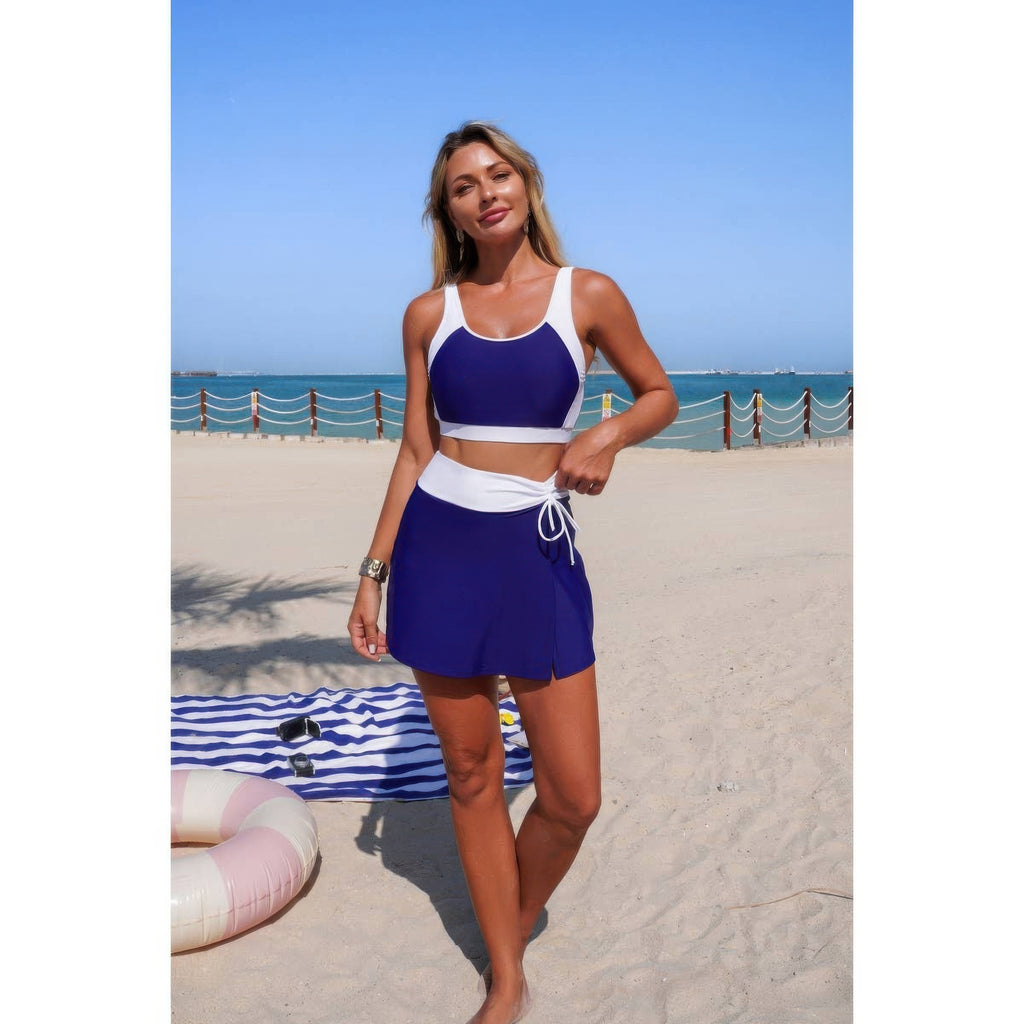 Two-piece color block bikini set, navy crop top with tie-front mini skirt bottom and white waistband