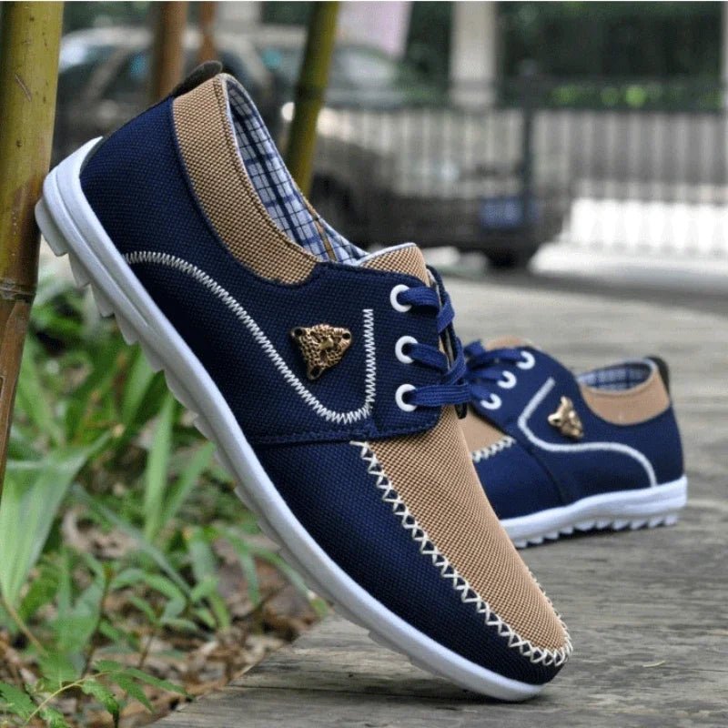 Men's flat canvas sneakers in navy blue with tan lining, lace-up, white rubber sole
