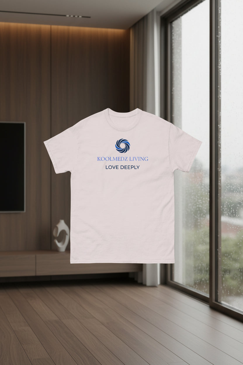 A light beige crewneck t-shirt with a blue and navy graphic on the chest featuring a swirl logo and the text 'KOOLMEDZ LIVING' and 'LOVE DEEPLY'.