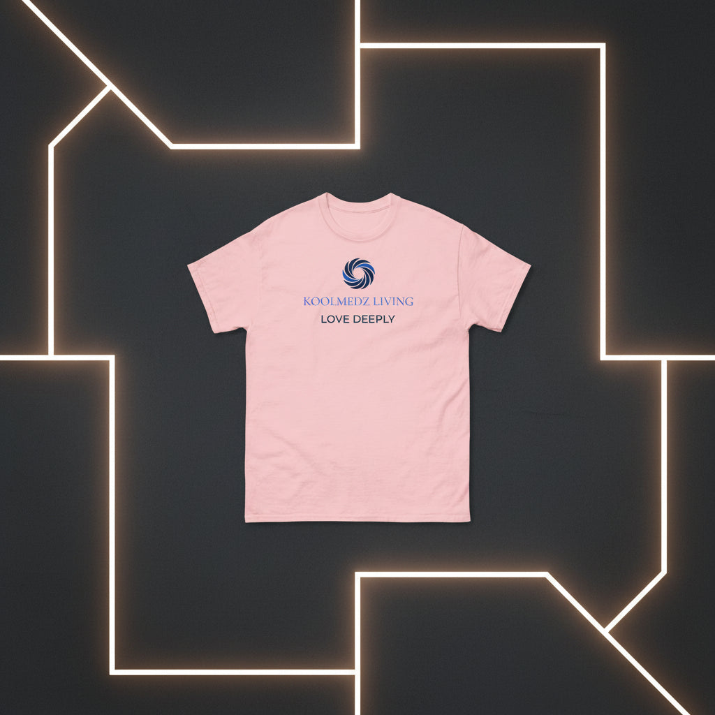 A light pink short-sleeve crewneck t-shirt with a blue and navy graphic on the chest. The graphic features a circular swirl logo above the text 'KOOLMEDZ LIVING' in blue and 'LOVE DEEPLY' in navy, displayed on a clean white background.