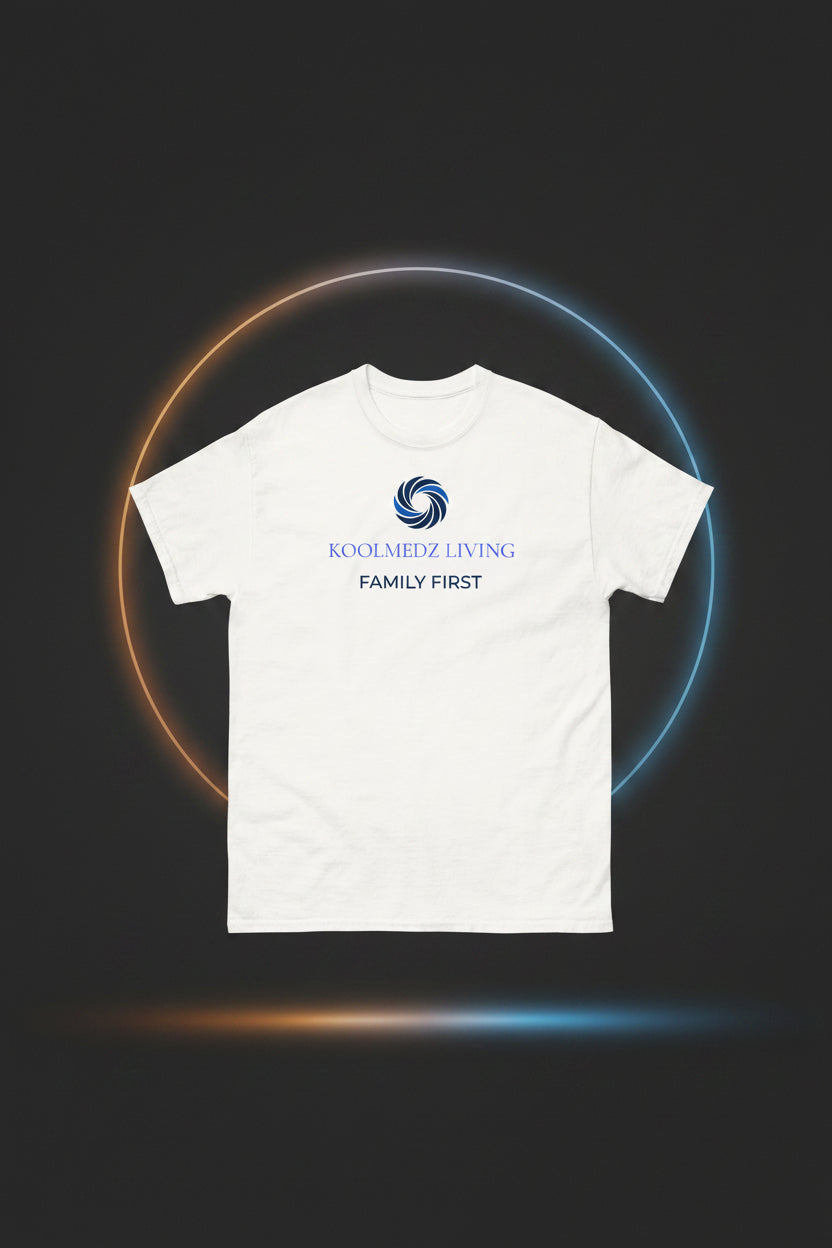 A white short-sleeve crewneck t-shirt with a blue and navy graphic on the chest. The graphic features a circular swirl logo above the text 'KOOLMEDZ LIVING' in blue and 'FAMILY FIRST' in navy.