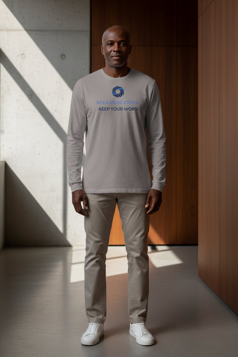 A long-sleeve crewneck t-shirt in a muted storm color, featuring a blue swirl logo and the text 'KOOLMEZ LIVING' and 'KEEP YOUR WORD' printed on the chest.
