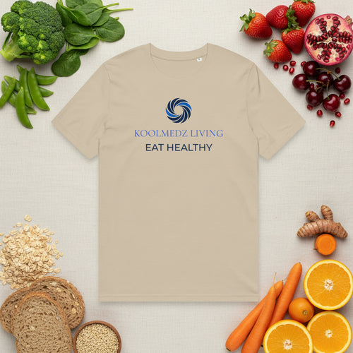 A beige short-sleeve crewneck t-shirt featuring a blue and navy circular logo and the text 'KOOLMEDZ LIVING' and 'EAT HEALTHY' printed on the chest, displayed against a solid white background.