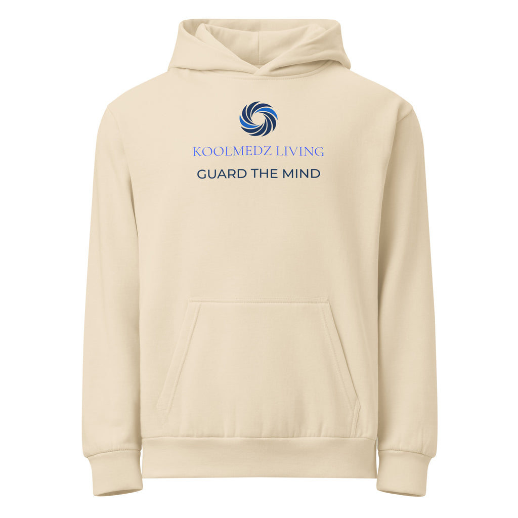 A cream-colored pullover hoodie with a front kangaroo pocket, featuring a blue and navy circular logo and the text 'KOOLMEDZ LIVING' and 'GUARD THE MIND' printed on the chest.